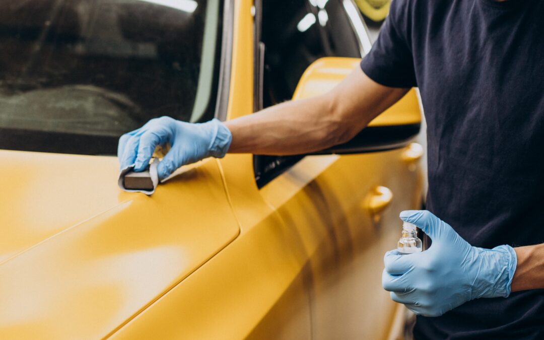 Man Sanding a Yellow Car with Blue Latex Gloves on