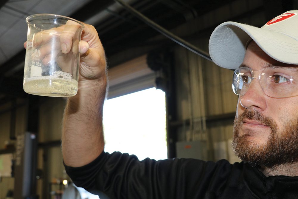 truebrand-backed-f2 Solid Start chemist inspecting a True Brand formulation in the lab